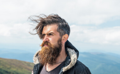 photo of bearded brutal man in the mountain. brutal man outdoor. brutal man has beard.