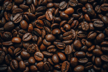 Roasted Arabic coffee beans are strewn on the table. Background formed by grains of roasted coffee close-up. Roasted coffee grain concept.