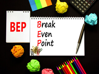 BEP break even point symbol. Concept words BEP break even point on white note on a beautiful black background. Pencil and pen. Calculator. Business and BEP break even point concept. Copy space.