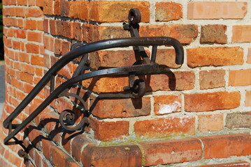Cast iron handrail on the background of a brick wall