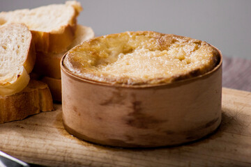 Spanish casar cheese on a wooden board with slices of bread. Queso Español. Tarta del casar.