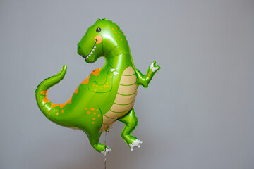 Naklejka premium green dinosaur hot air balloon on gray background