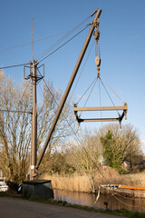 Travel lift or boat hoist on a canal side in rural countryside town Warfhuizen Groningen Netherlands on a sunny day. Dutch gantry crane used in Holland to lift boats out of the water for maintenance.