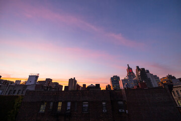 NEW YORK, NEW YORK USA – OCTOBER 22, 2022: Sky glows over the East Village cityscape during twilight in New York City.
