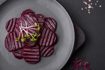 Delicious healthy boiled ruby-colored beets sliced ??on a black plate