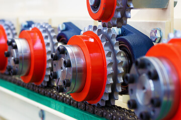 Detail of colorful cogs, pulleys and a traction chain of a industrial machinery