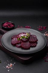 Delicious healthy boiled ruby-colored beets sliced ??on a black plate