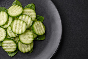 Delicious healthy raw cucumber sliced ??on a black ceramic plate