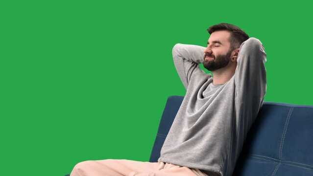 Happy relaxed man on couch stress free life balance home recreation isolated green screen chroma key