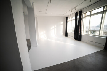 Interior of a photo studio. White cyclorama with sunlight.