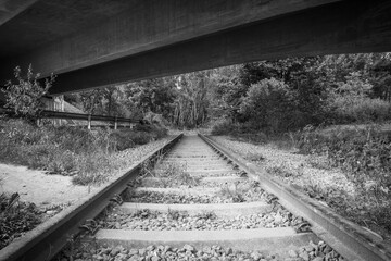 old railway tracks under a bridge