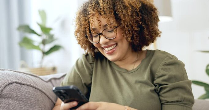 Phone, texting and black woman laugh at funny meme on social media, internet and web sitting on a couch or sofa in a home. Browsing, scrolling and person in living room using wifi to send message