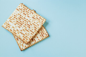 Happy Passover banner. Matzo on a blue background. Traditional Jewish food for Pesach. Copy space.
