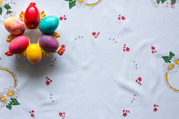 Top view of colored easter eggs on a white tablecloth
