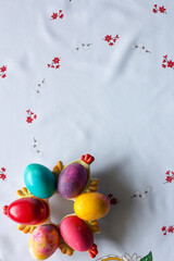 Top view of colored easter eggs on a white tablecloth