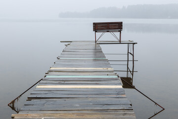 Early foggy morning at b a small wooden pier on the lake. Masuria, Poland.