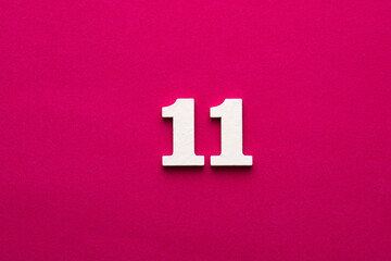 Number 11 - White wooden number on rhodamine red background
