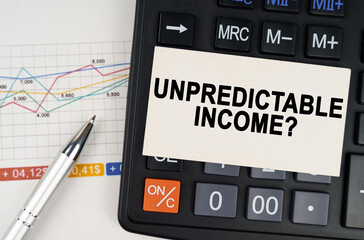 On the business chart lies a pen, a calculator and a business card with the inscription - Unpredictable income