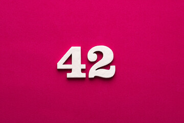 Number 42 - white number in wood on rhodamine red background