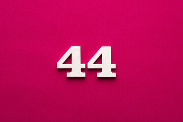 Number 44 - white number in wood on rhodamine red background