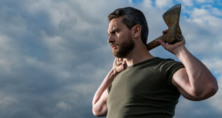 confident man with axe. caucasian man holding ax. brutal man on sky background. copy space