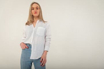 Portrait of a young, emotional, happy girl without makeup, smiling at the camera, gesturing with her hands, standing on a white background. Place for writing	
