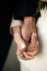 Happy couple of people holding hands close up. Groom and bride, wedding ceremony. Love, support