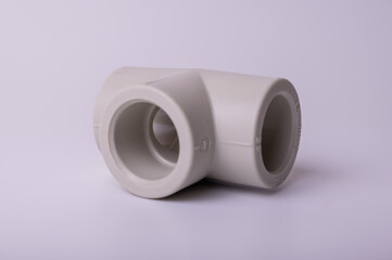 light PVC pipe tee connection for water isolated on light background close up.