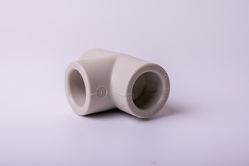 light PVC pipe tee connection for water isolated on light background close up.
