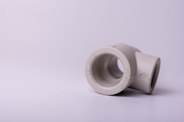 light PVC pipe tee connection for water isolated on light background close up.