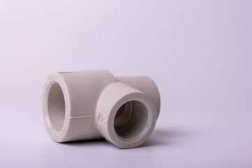light gray PVC pipe tee connection for water isolated on light background close-up. side view, top view