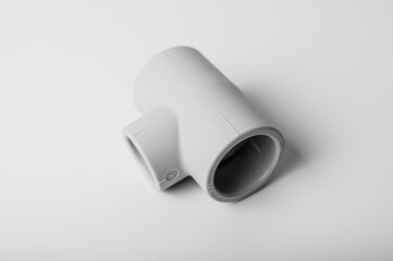 light gray PVC pipe tee connection for water isolated on light background close-up. side view, top view