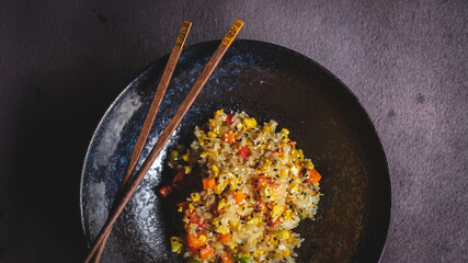 Rice with seafood and vegetables in a beautiful plate on a dark textured background