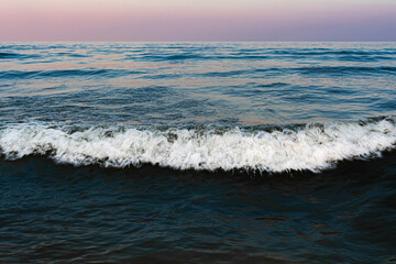 Sea wave with foam. Night scene after sunset. Seascape background