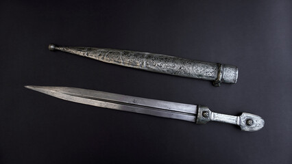  antique, silver dagger with scabbard on a black background. 