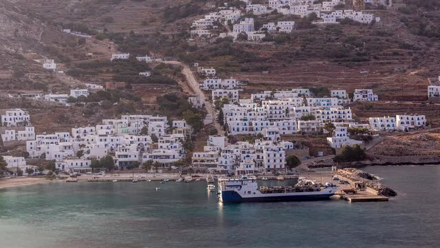 Amorgos island aerial timelapse from above at morning. Traditional Greece - white houses on hills and ship in sea port in harbor, Cyclades