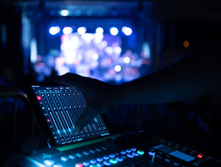 Sound Technician operating audio board at music festival stage