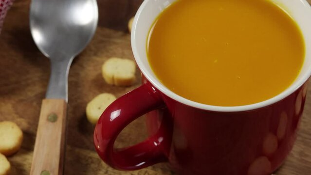 bol de soupe aux l&eacute;gumes et croutons, en gros plan, sur une table