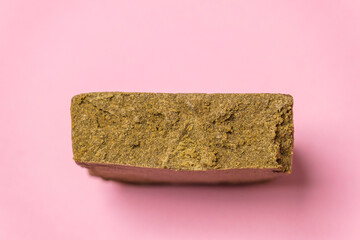 Gelato OG Autodry hash. Medical marijuana extraction super dry hashish high quality cannabis pollen on a pink background.