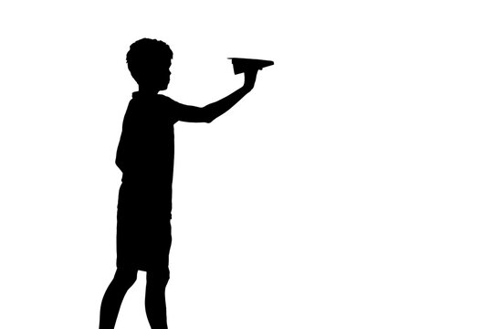 recommend clip art: Small boy holds a paper plane in hand by the river at beautiful orange sunset in summer. silhouette of a boy with origami plane standing near the lake