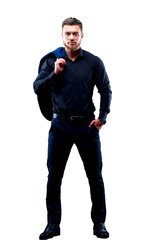 Fashion portrait of young man in black shirt. Man poses over dark wall with one hand in pocket. Handsome confident man, businessman, modern clothes.