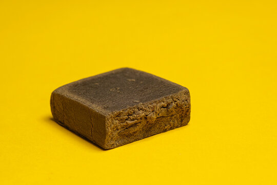 Hashish stick ready for sale on a yellow background. Medical marijuana extraction dry hashish cannabis pollen.