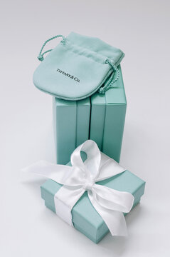 Tiffany boxes side by side, one Tiffany box with a silk ribbon and fabric cover.