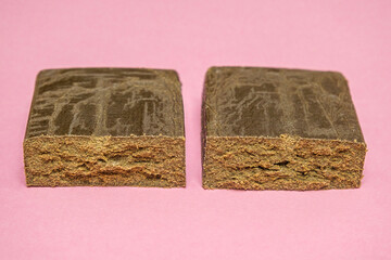 Peach ozz dry base hash. Medical marijuana extraction super dry hashish high quality cannabis pollen on a pink background.