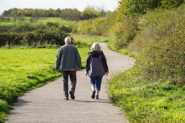 Senior couple walking in a park in autumn - Powered by Adobe