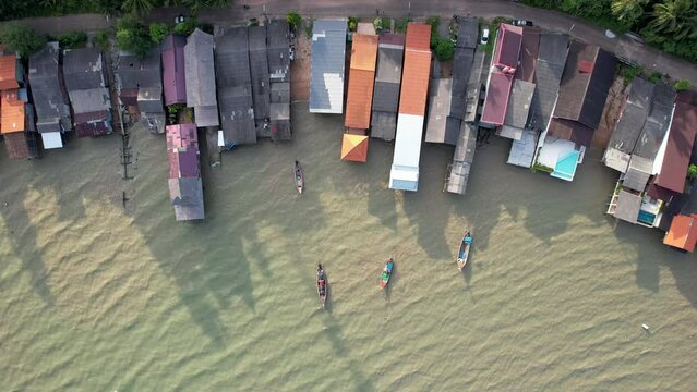 Slide drone footage of the town at high tide on sunny day. Ko Lanta Old Town, Krabi Province, Thailand.