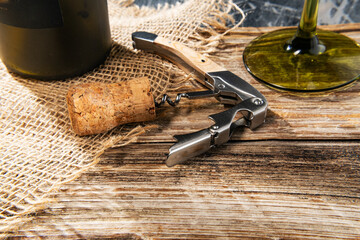 Corkscrew, cork and bottle of wine on board