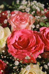 top view of pink and white roses flowers bouquet with greens. 