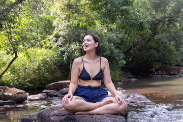 Mujer joven al aire libre realizando yoga y meditación.