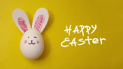 Greeting card for the holiday Happy Easter. Handdrawn frame-by-frame animation. Cute bunny face and rabbit ears on white chicken egg on yellow background. Handwritten congratulations text. Copyspace - Powered by Adobe